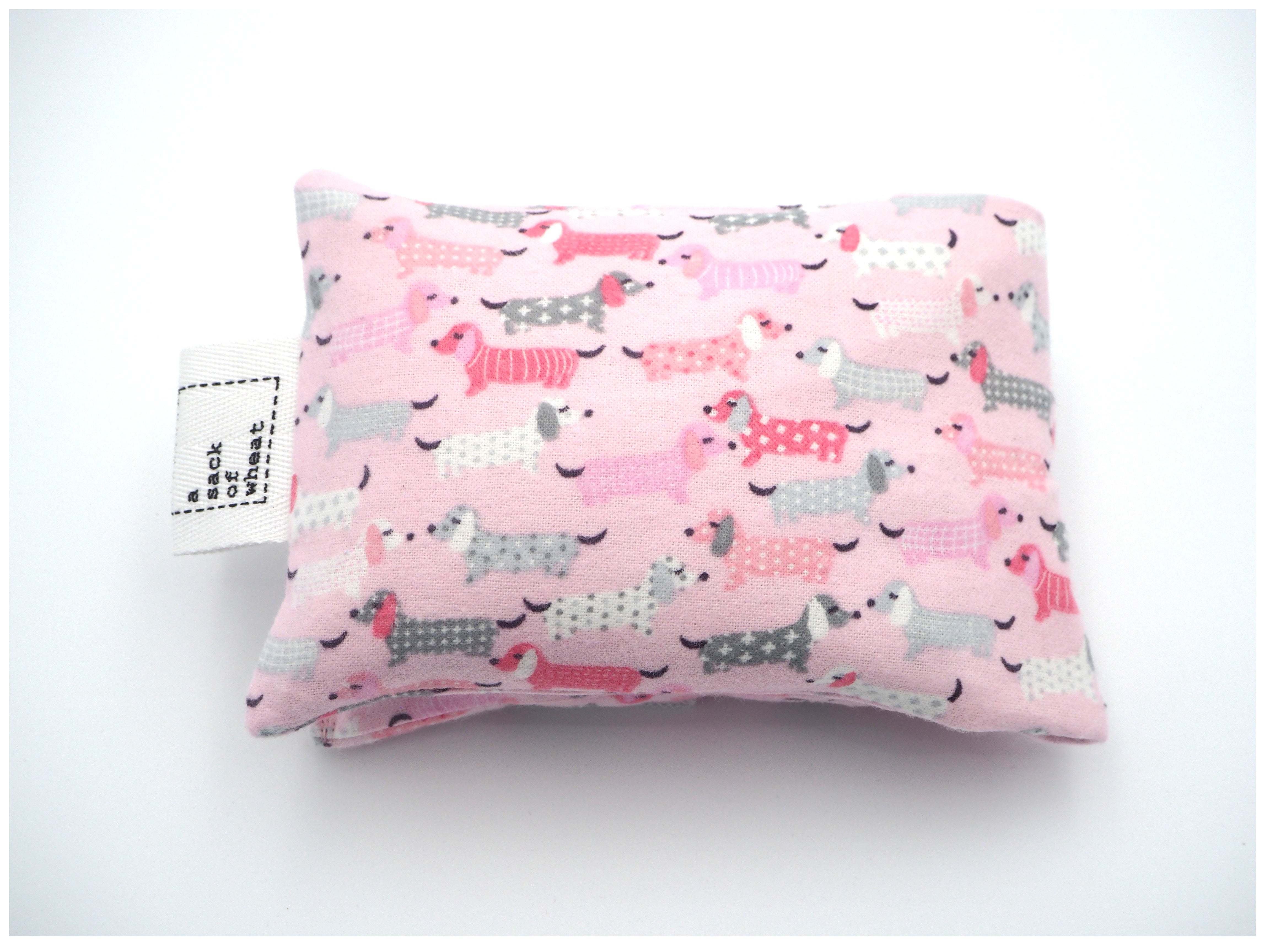 Folded view of A Sack Of Wheat, featuring pink, fluffy Dash Hounds on soft flannelette, 100% cotton fabric