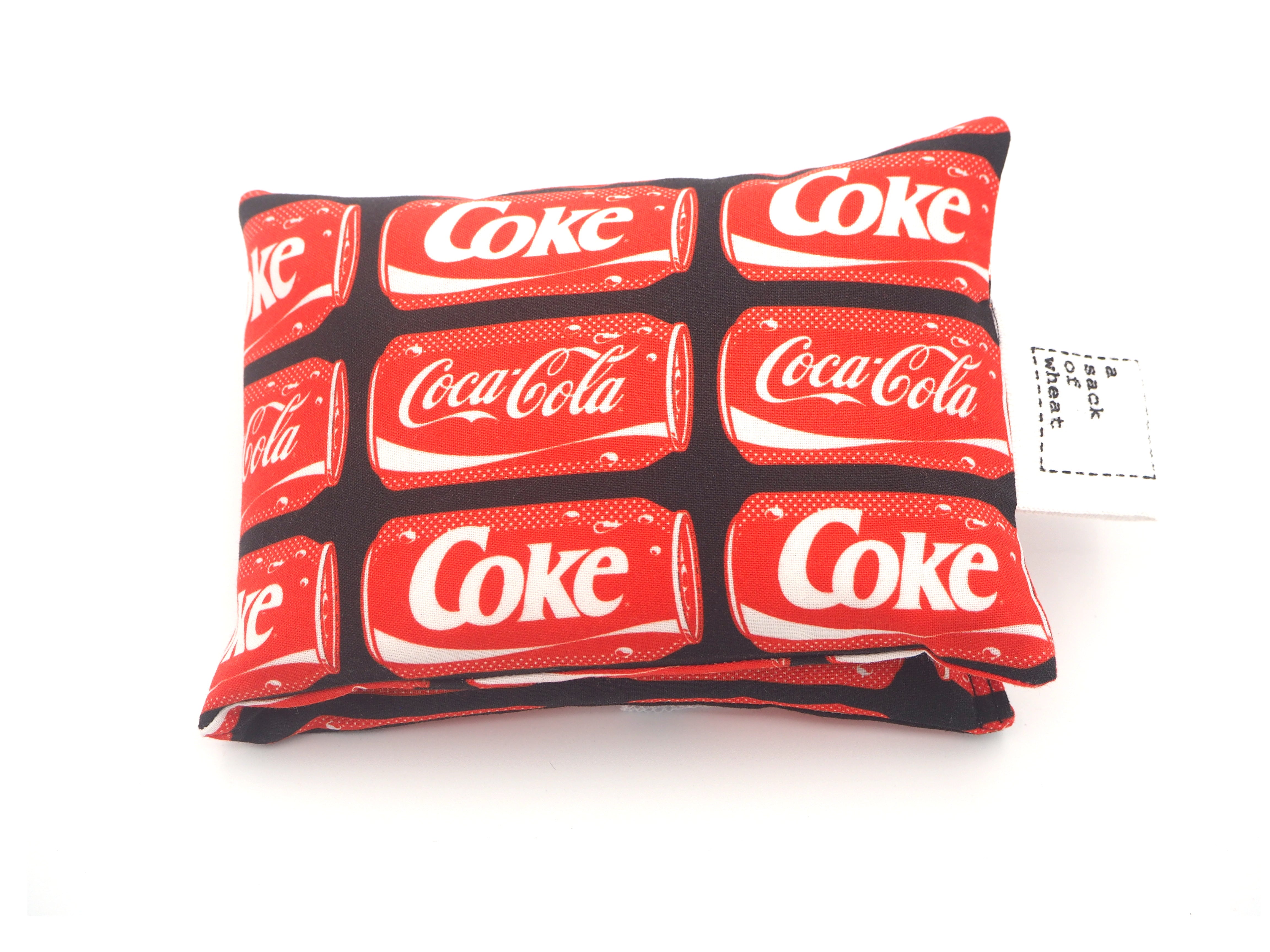 Folded view of A Sack Of Wheat, featuring classic red soft drink cans, 100% cotton fabric