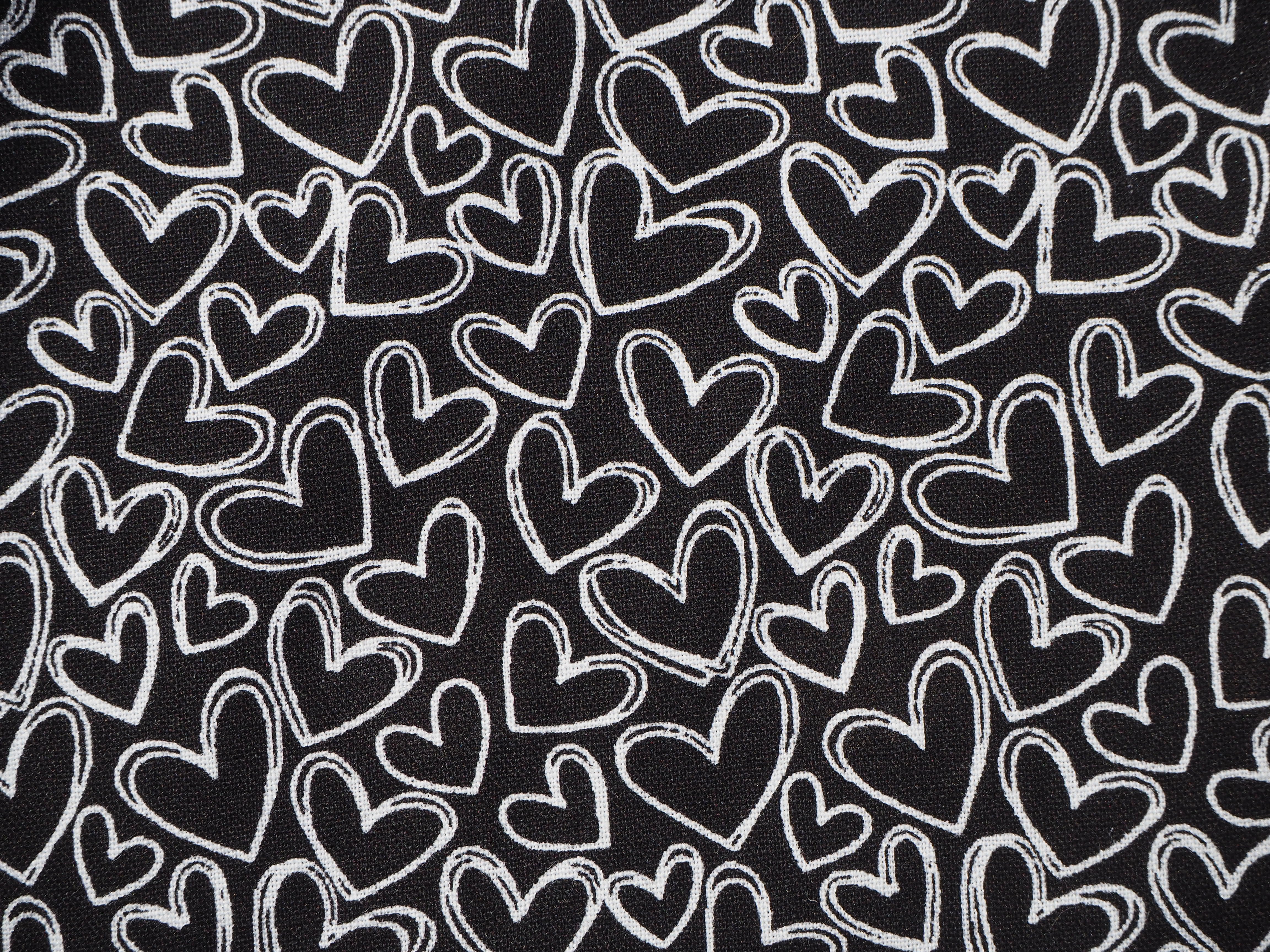 Fabric view of A Sack Of Wheat, featuring black & white hearts on black background,100% cotton fabric