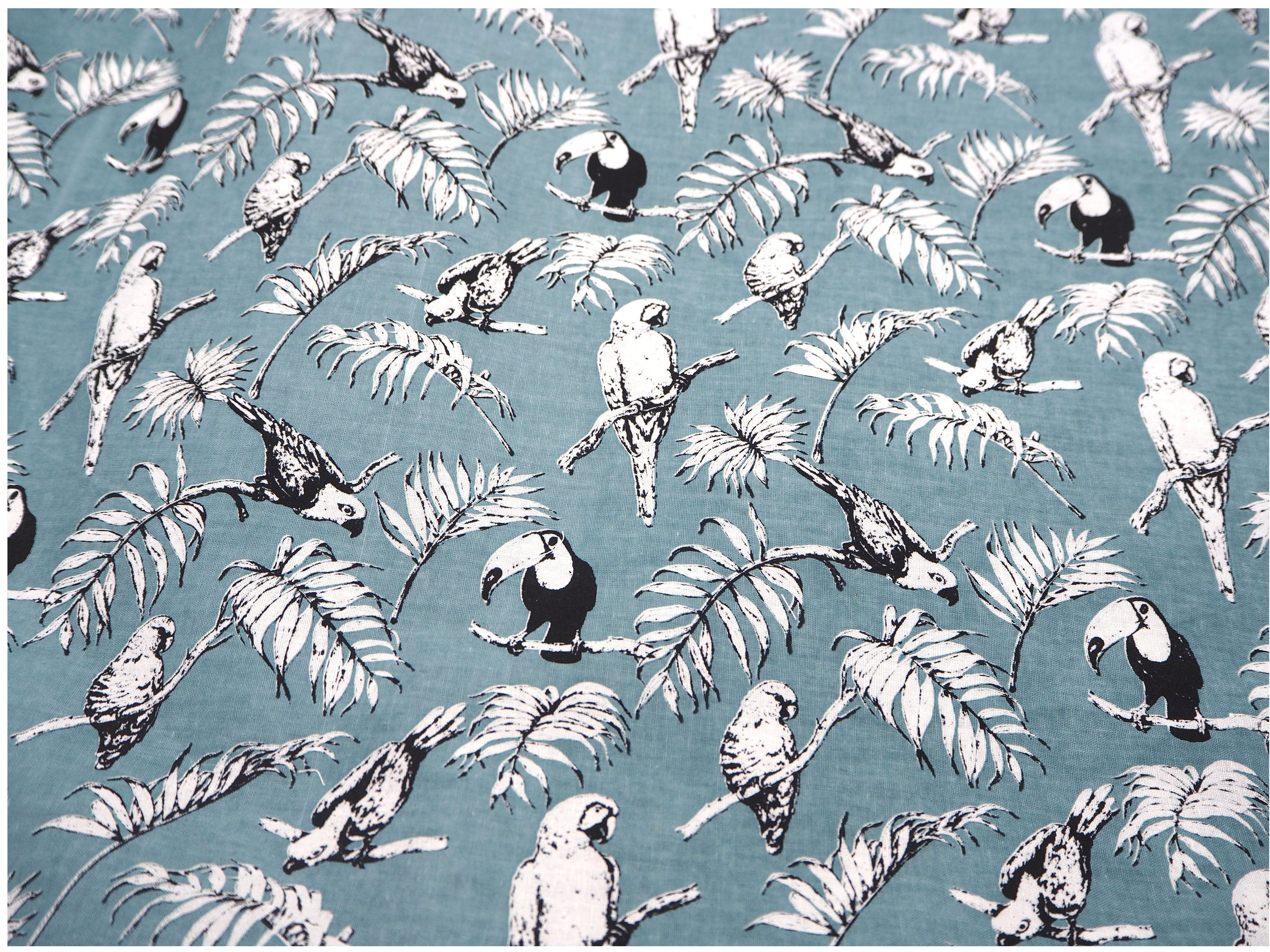 Fabric view of A Sack Of Wheat, featuring beautiful Toucans & Parrots, on a soft blue background, 100% cotton fabric