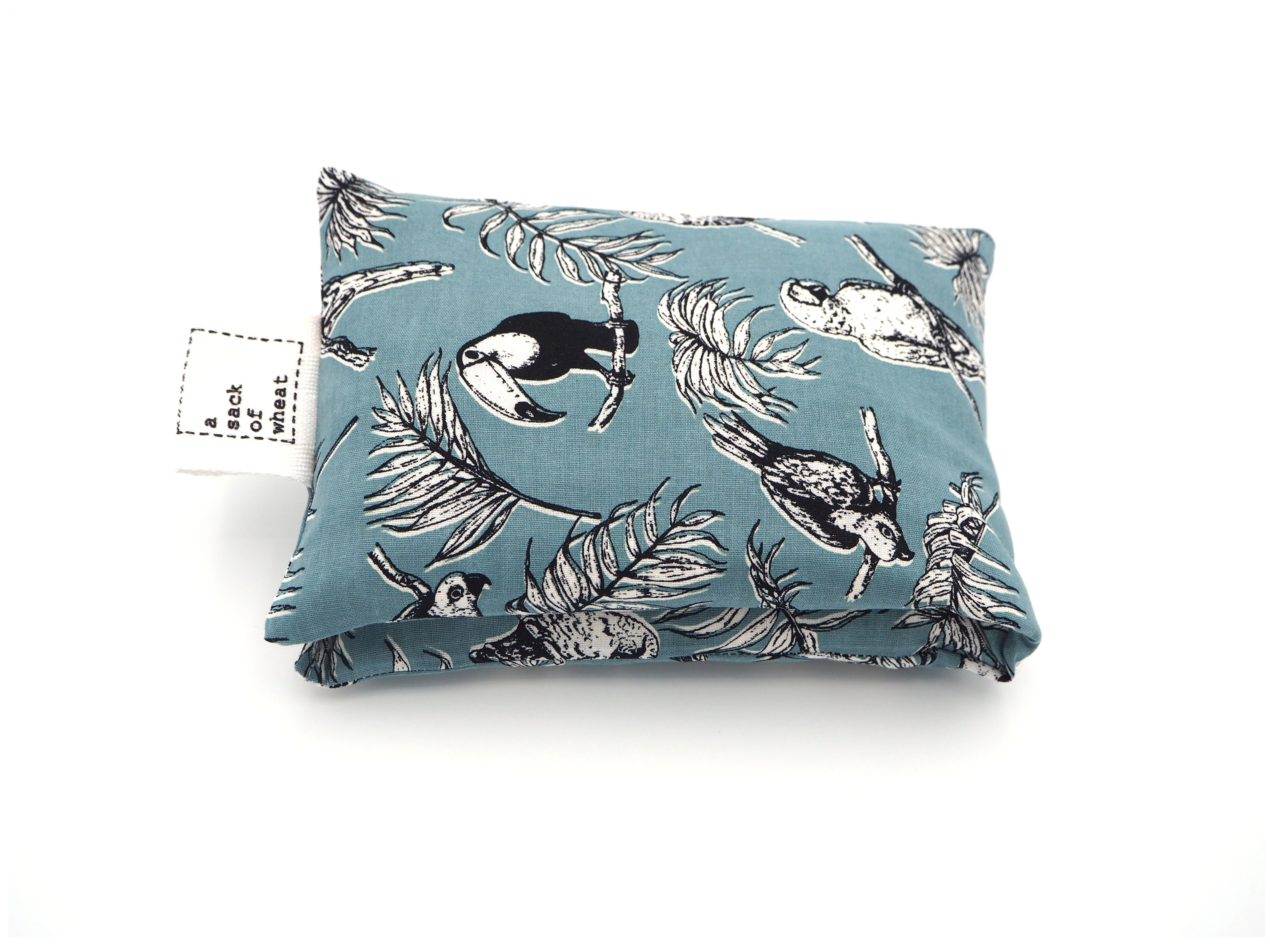 Folded view of A Sack Of Wheat, featuring beautiful Toucans & Parrots, on a soft blue background, 100% cotton fabric
