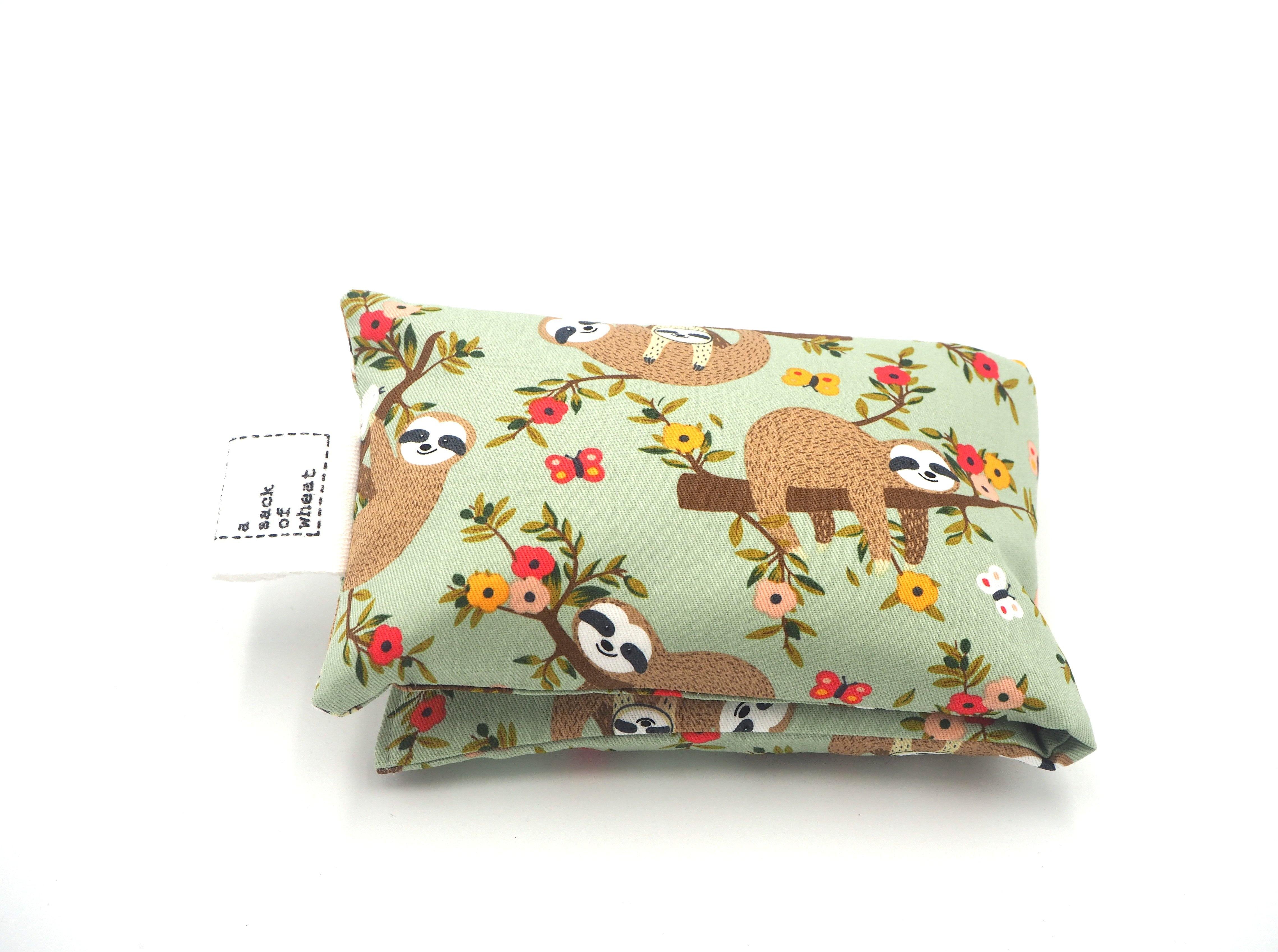 Folded view of A Sack Of Wheat, featuring Hanging Around Sloth Family images on soft green background, 100% cotton fabric