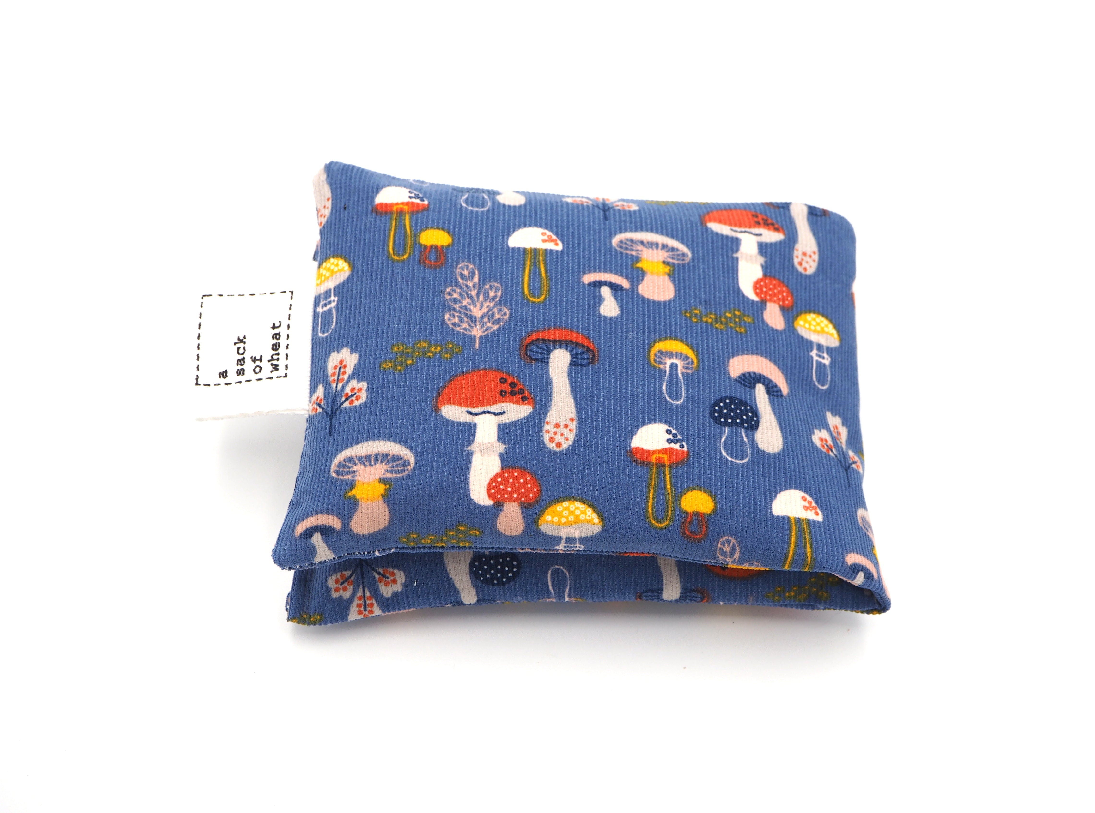 Folded view of A Sack Of Wheat, featuring cute, colorful mushrooms on blue corduroy 100% cotton fabric