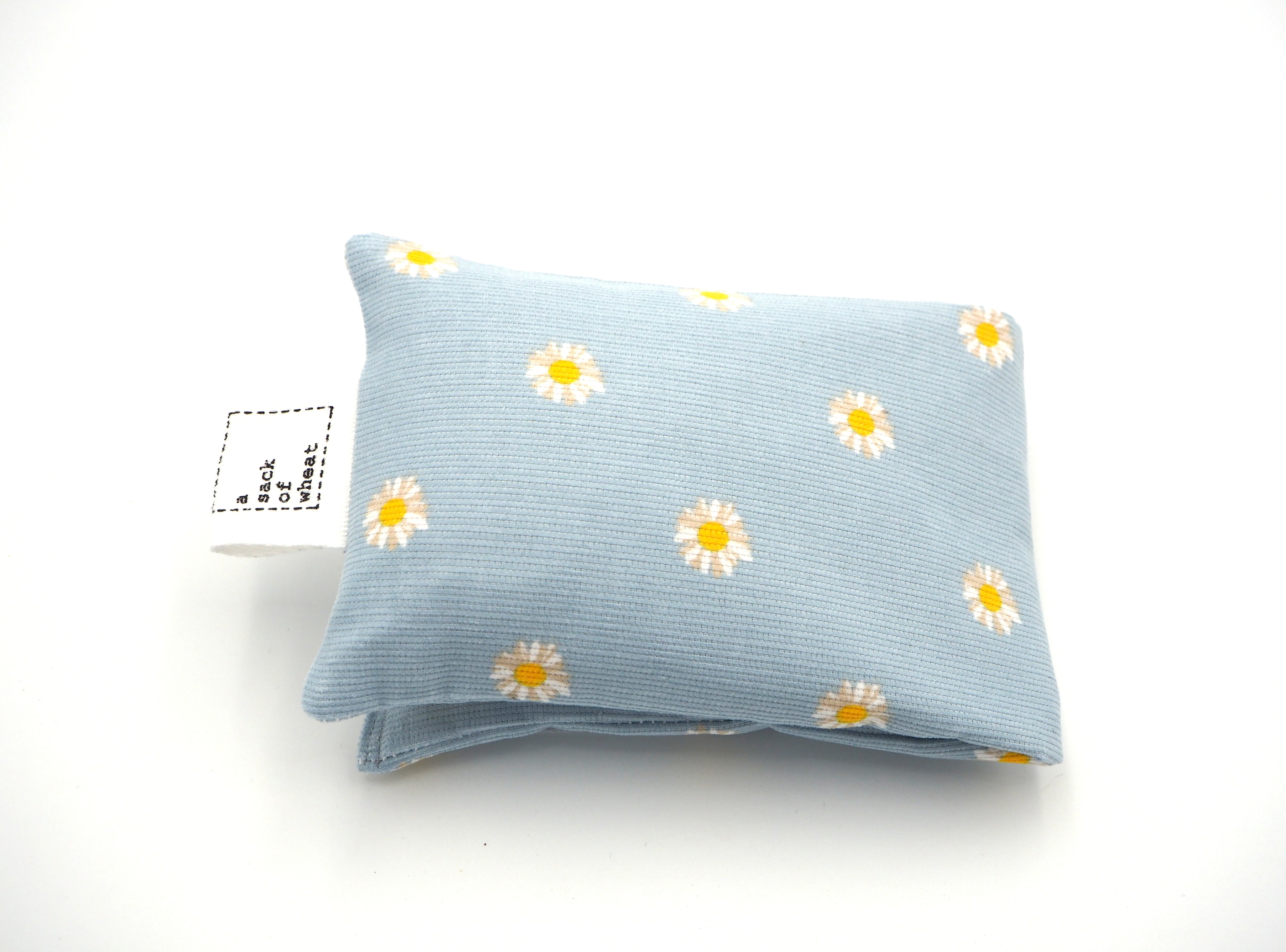 Folded view of A Sack Of Wheat, featuring soft yellow, spring daisy's on baby blue corduroy 100% cotton fabric