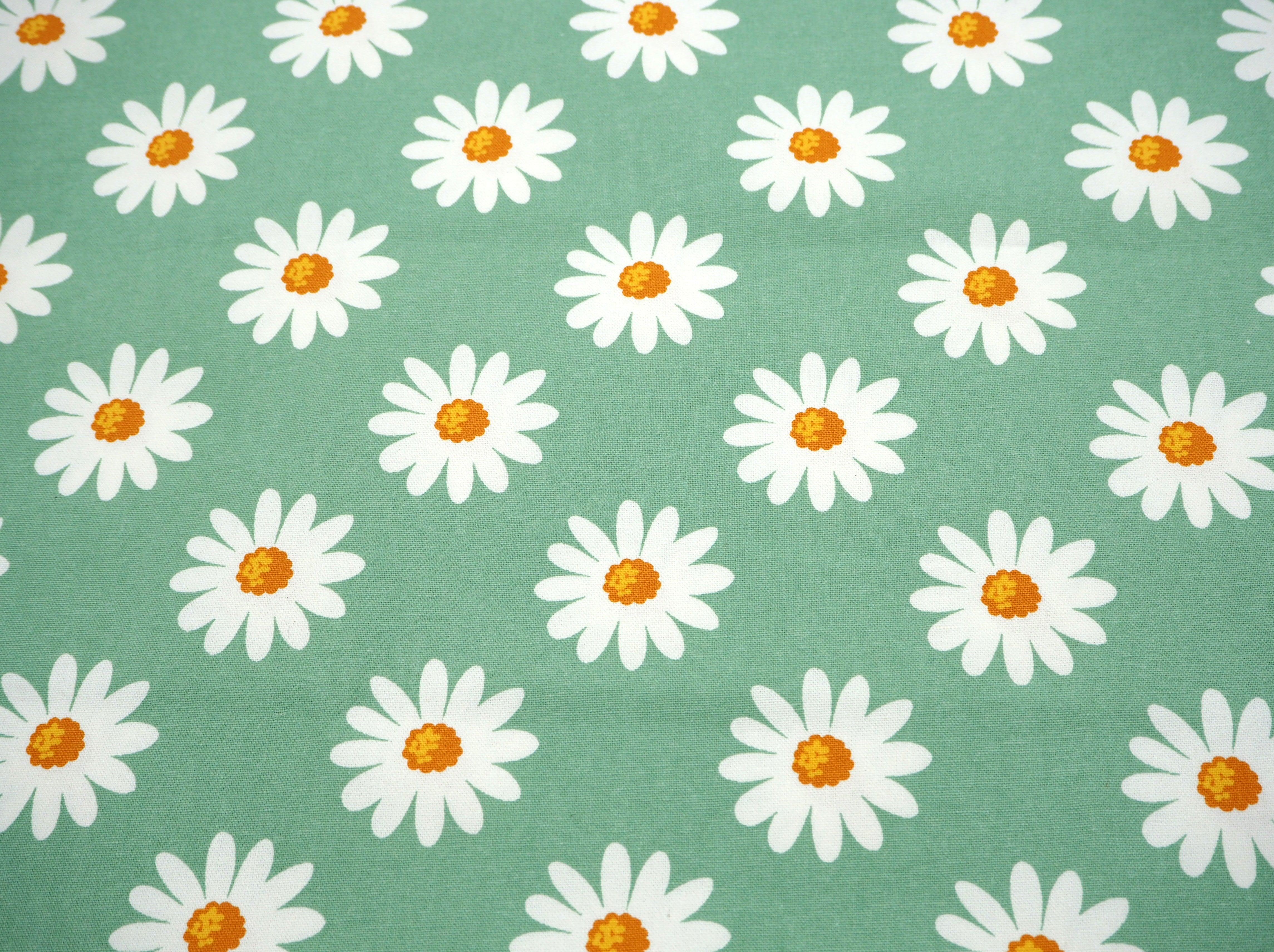 Fabric view of A Sack Of Wheat, featuring spring daisy's on classic vintage green background , 100% cotton fabric