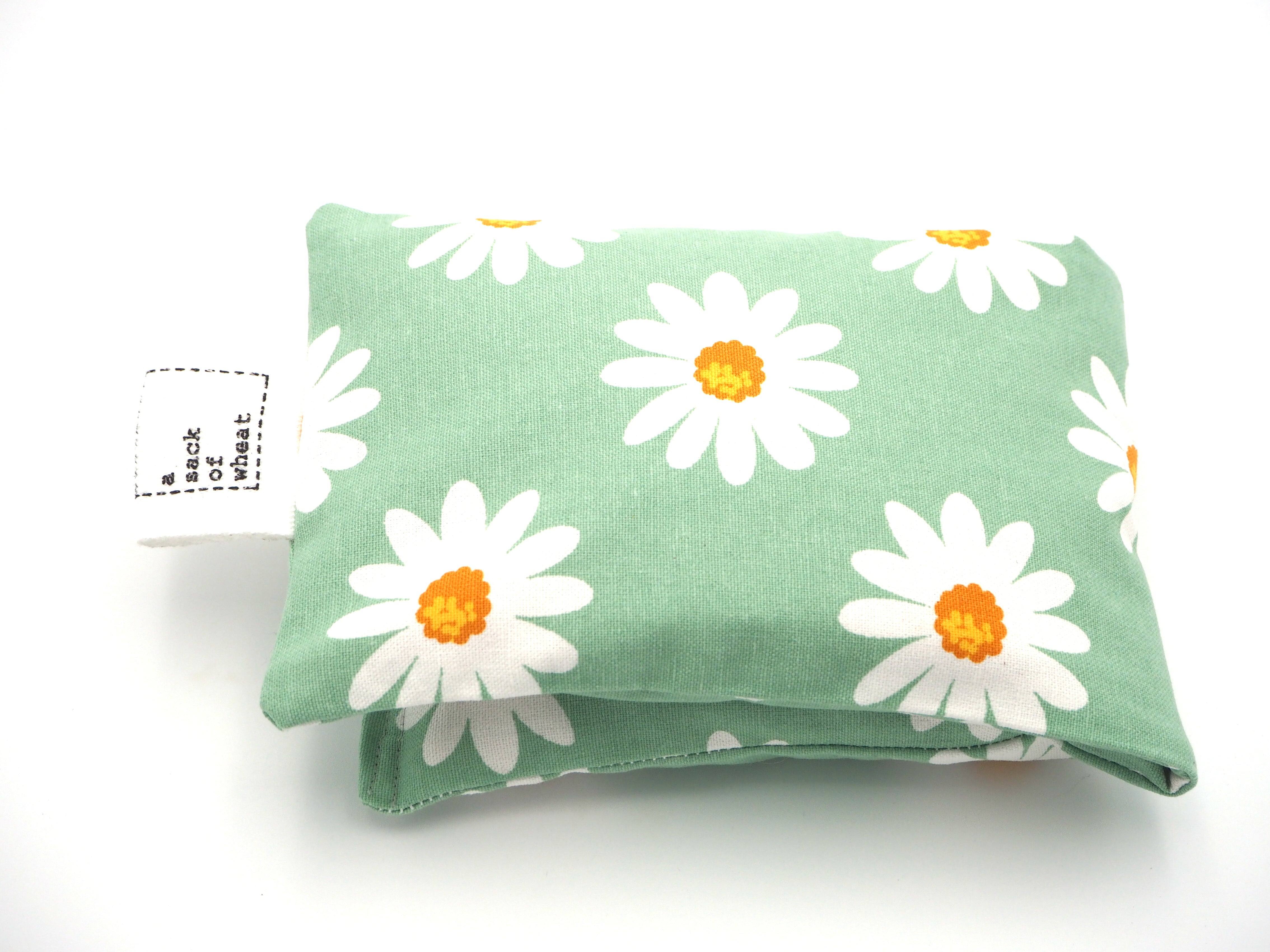 Folded view of A Sack Of Wheat, featuring spring daisy's on classic vintage green background , 100% cotton fabric