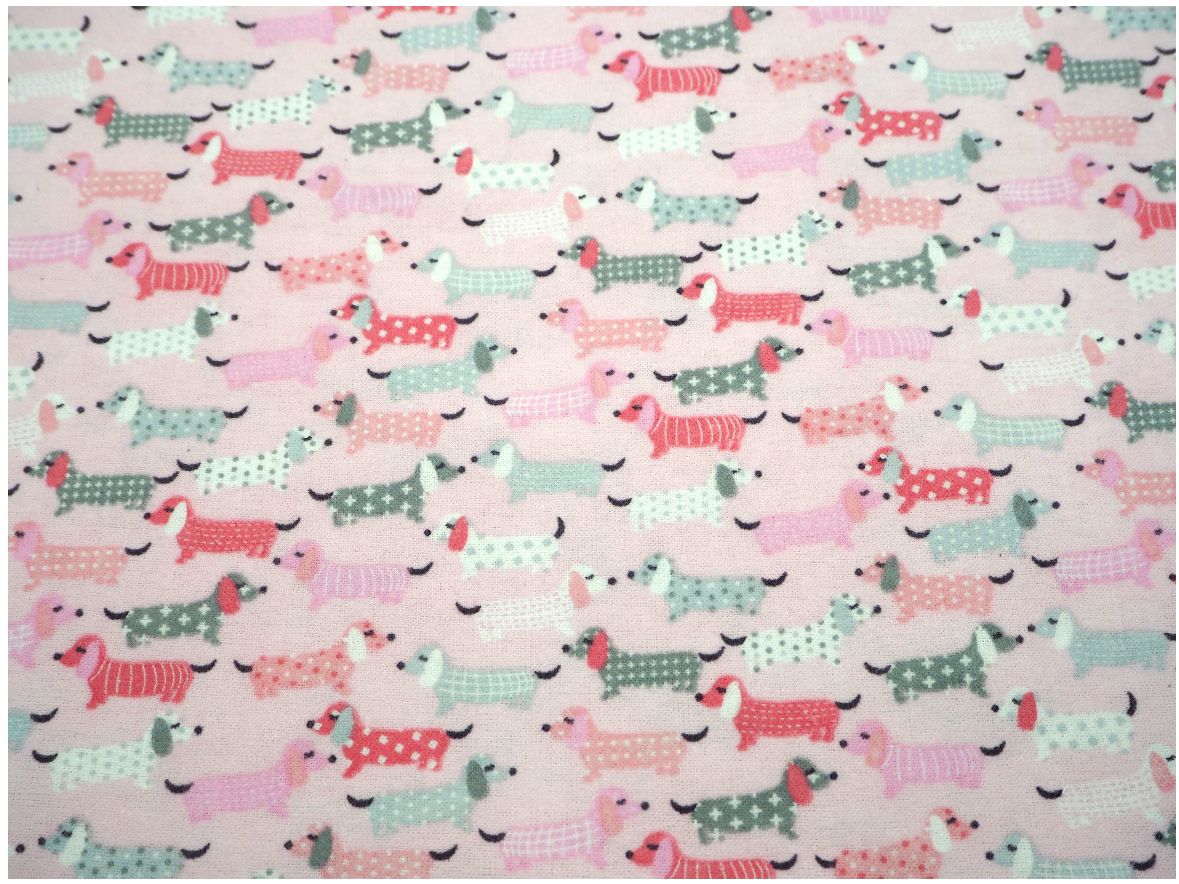 Fabric view of A Sack Of Wheat, featuring pink, fluffy Dash Hounds on soft flannelette, 100% cotton fabric