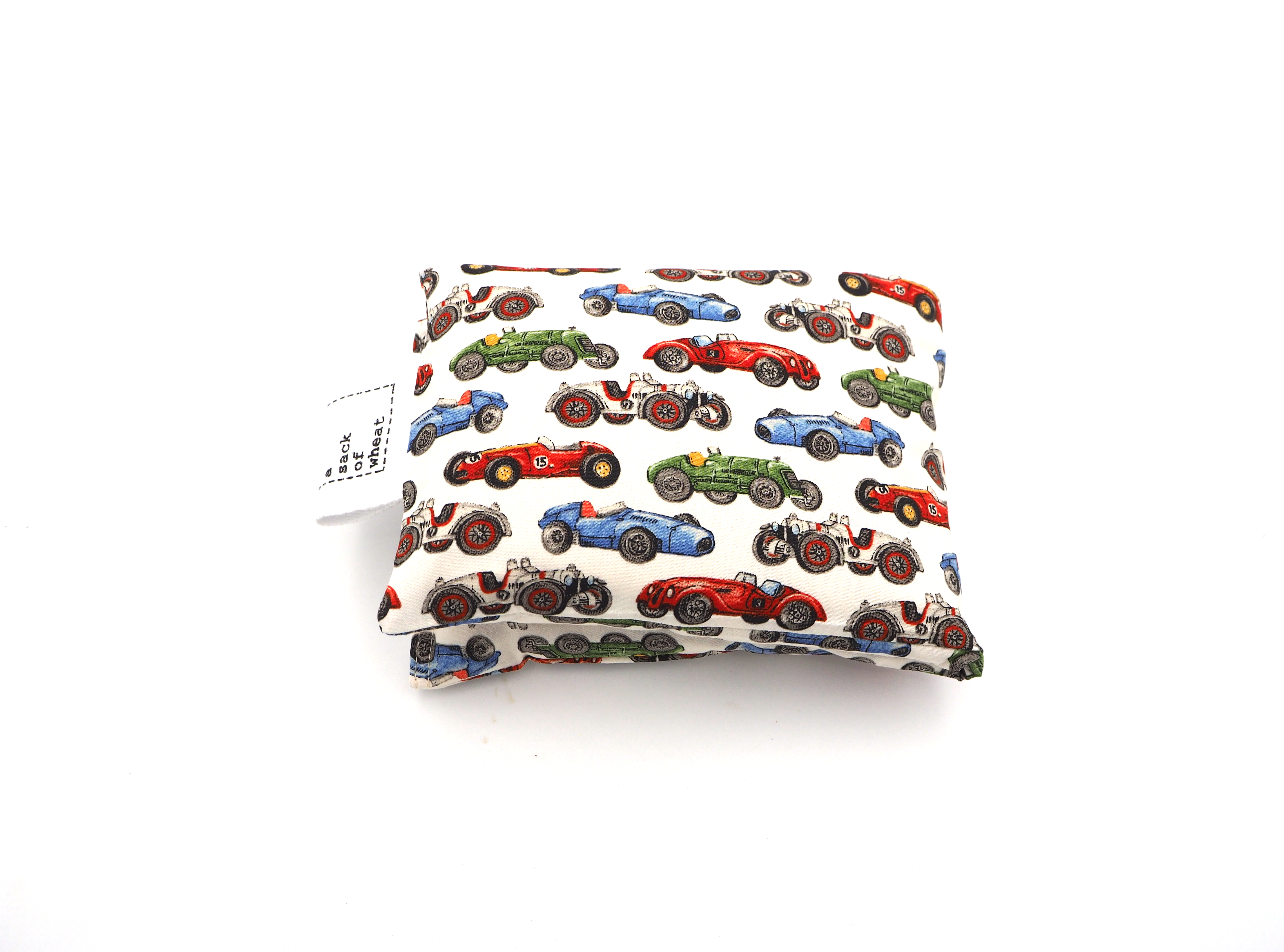 A folded wheat bag featuring images of colorful Vintage racing cars on cotton fabric.