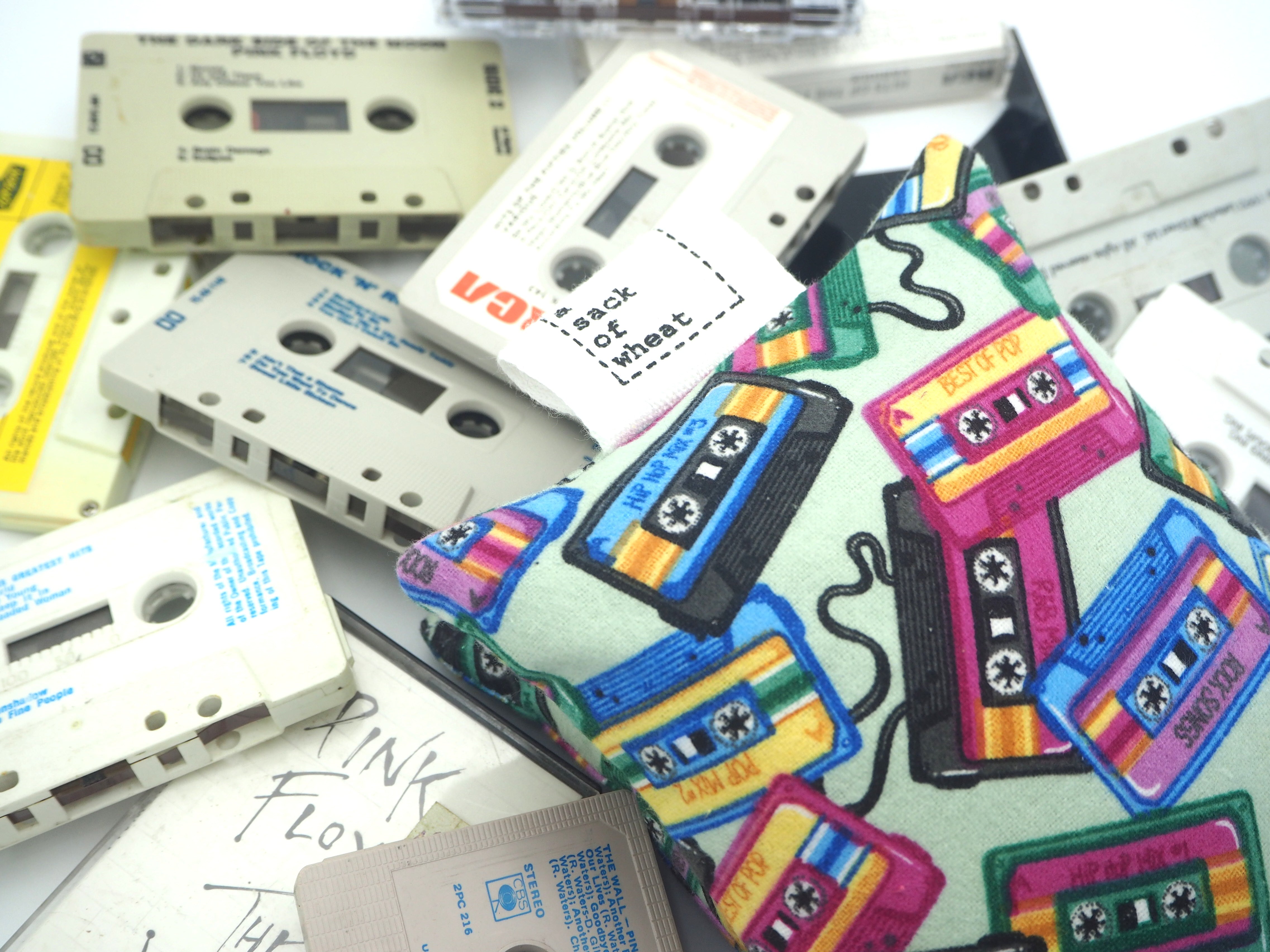 Folded view of A Sack Of Wheat, featuring colourful cassette tapes on soft sage green flannelette, 100% cotton fabric