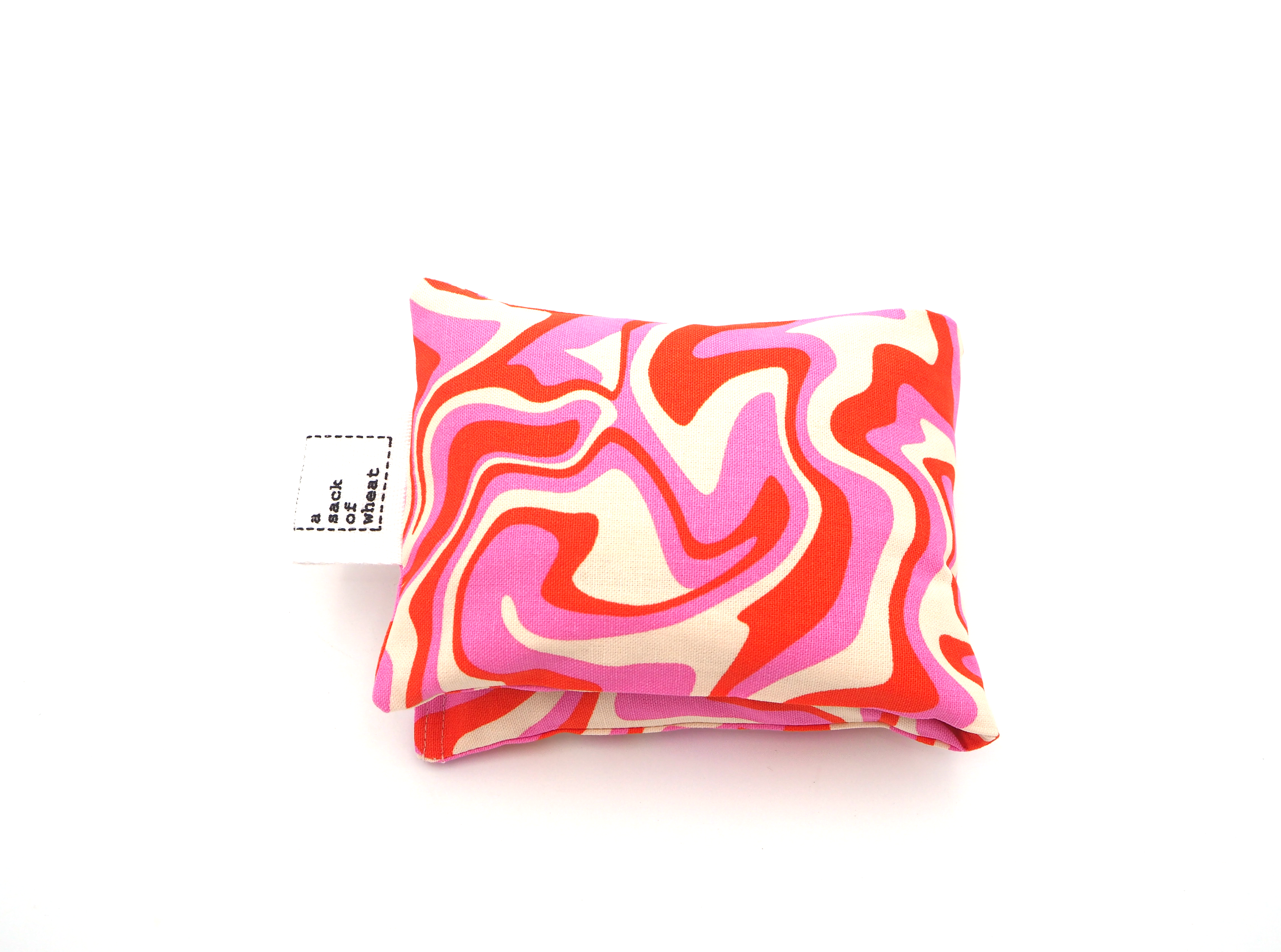 Folded view of vibrant pink, orange & cream patterned wheat bag, 100% cotton