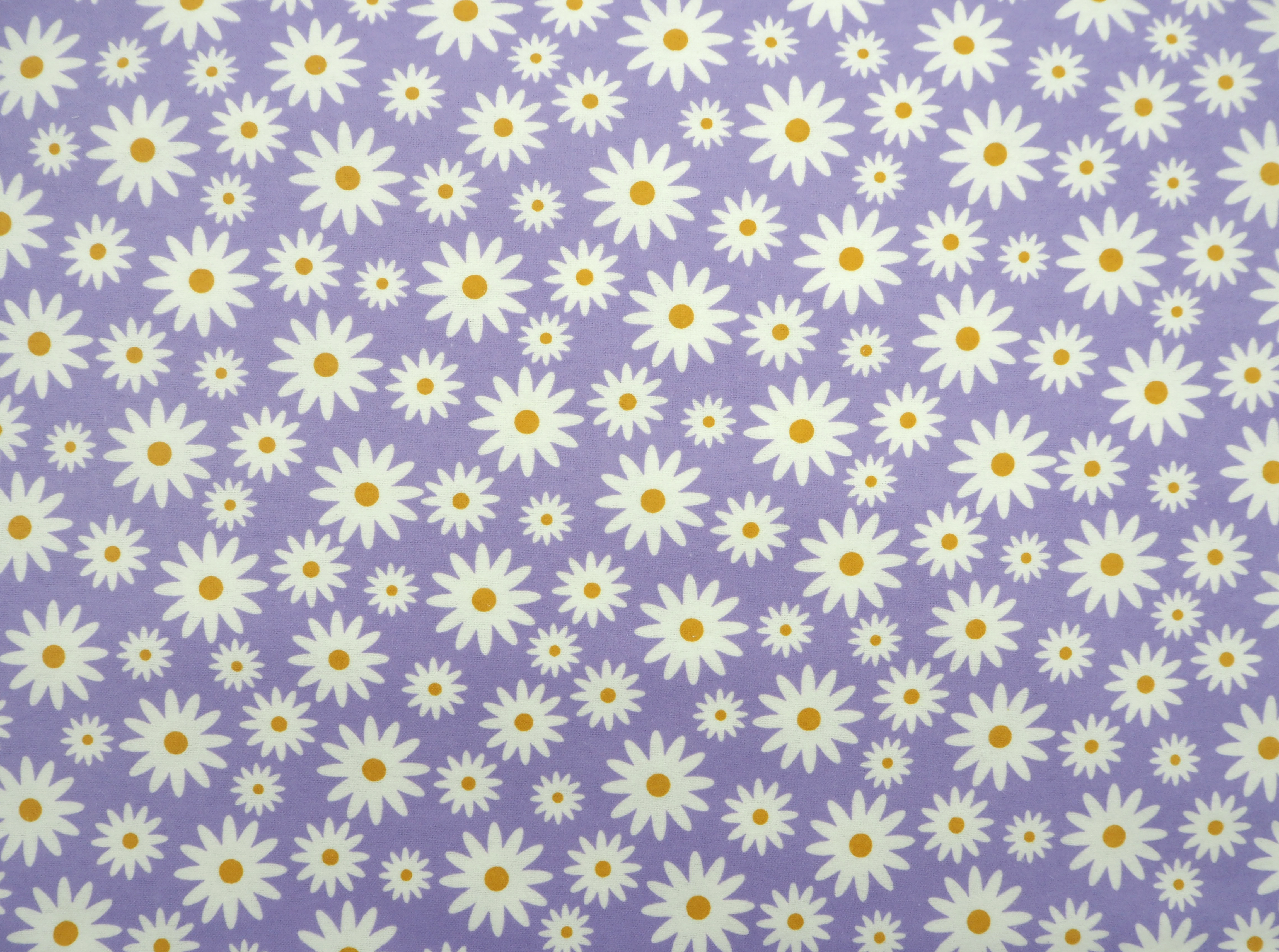 fabric featuring white daisy pattern on a purple background