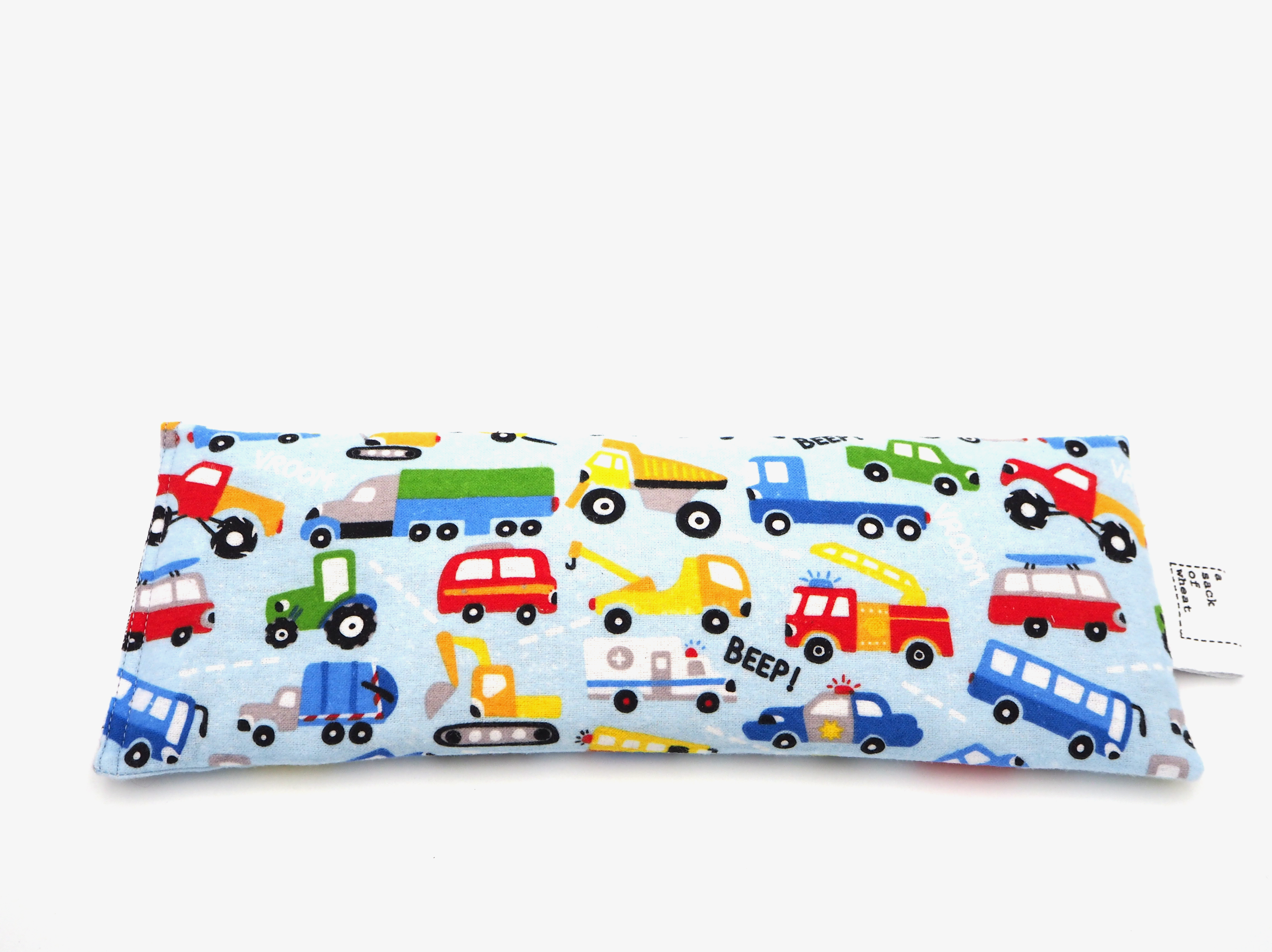 Flat image of soft blue flannelette fabric featuring colorful toy trucks, cars, buses and tractors, 100% cotton fabric. This wheat bag is called Wesley's Wheels