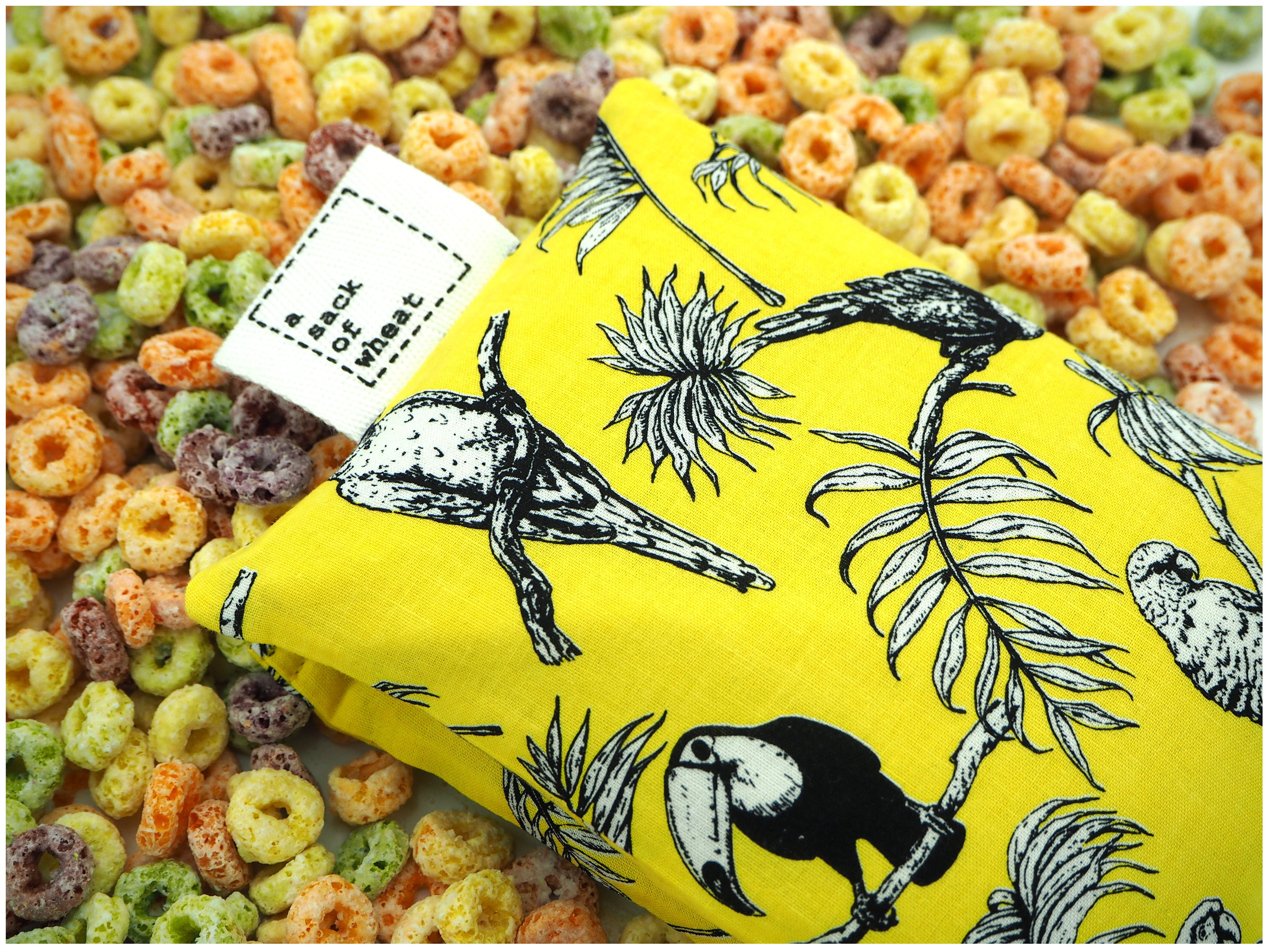 Folded view of A Sack Of Wheat, featuring Parrots & Toucans on a bright yellow background, 100% cotton fabric