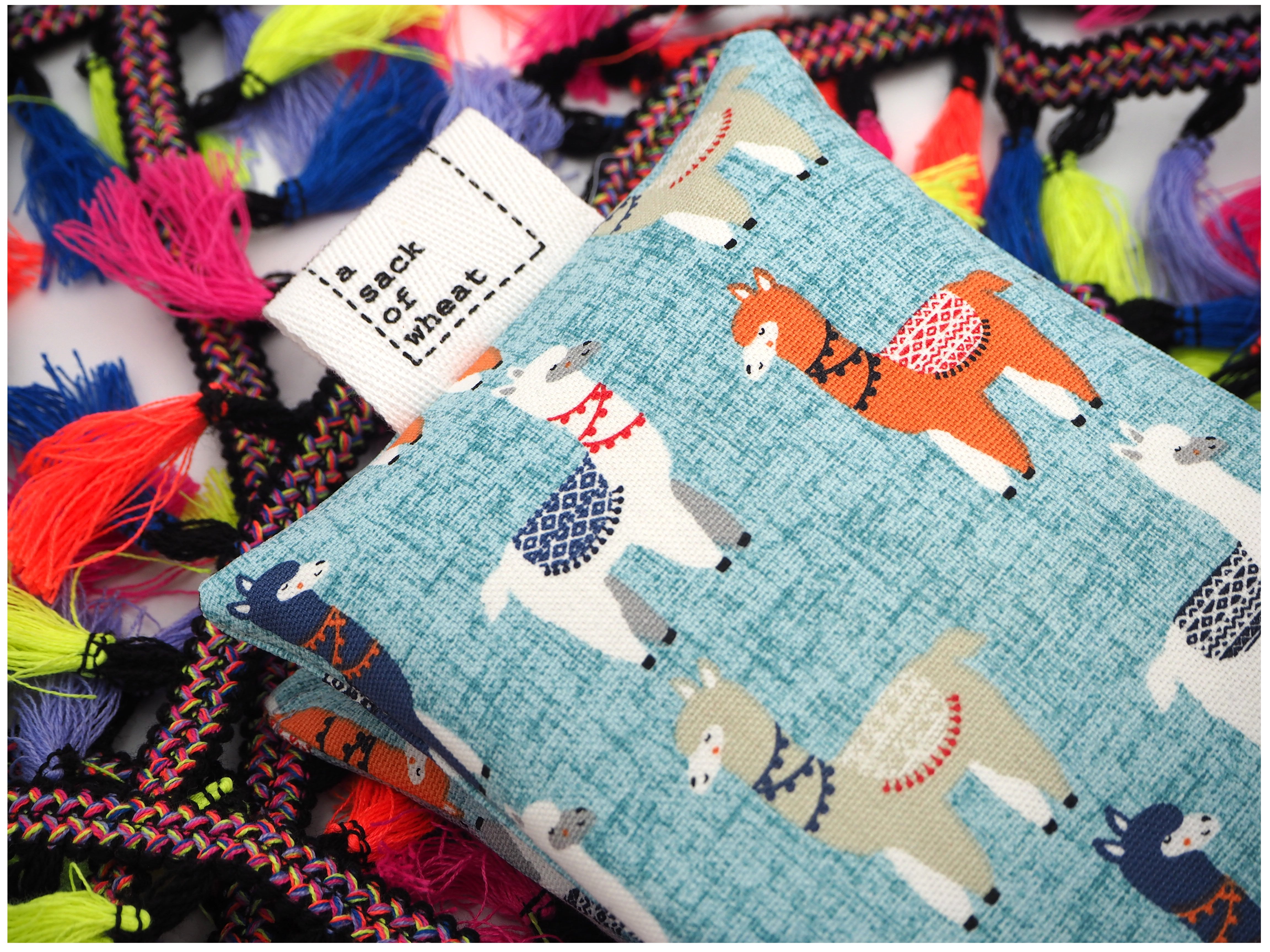 Folded view of A Sack Of Wheat, featuring colorful Llamas on soft blue background, 100% cotton fabric